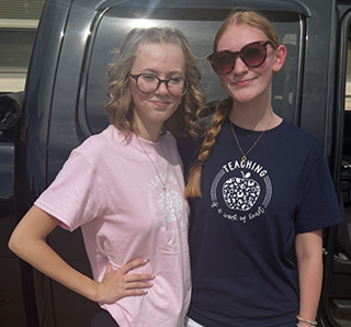 Two students wearing shirts with Cricut designs